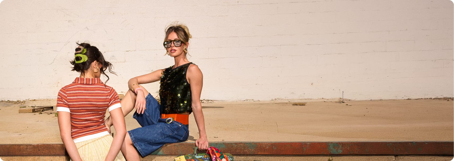 Two people sitting on a wooden bench with a plain background
